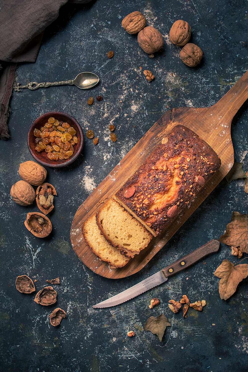 Sliced rustic loaf with garlic and sesame on a dark blue surface